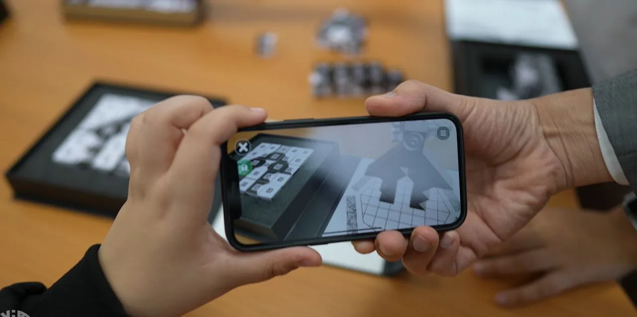 A phone showing a 3D model above a NEOMI board